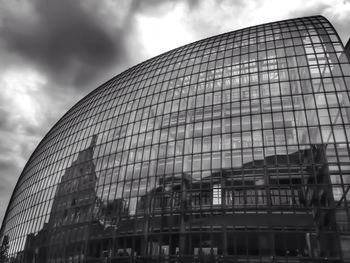 Low angle view of modern building against cloudy sky