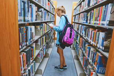 Rear view of woman standing in library