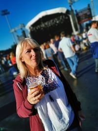 Portrait of a woman drinking drink in city