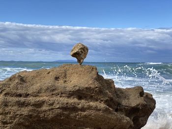 View of rock on beach against sky