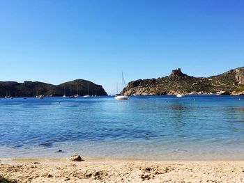 Scenic view of beach against clear blue sky