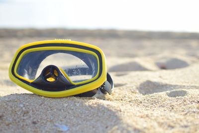 Close-up of sunglasses on sand