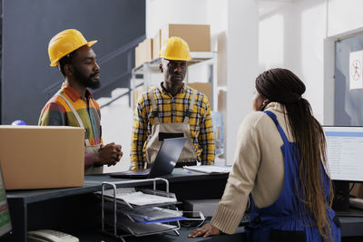 Rear view of people working at office