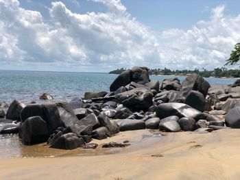 Rocks on beach against sky