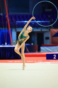 Girl gymnast performs an exercise with a hoop