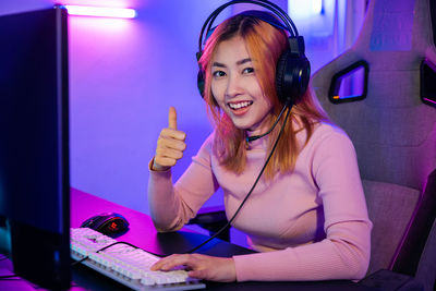 Young woman using phone while sitting at home