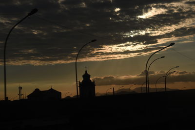 Silhouette of buildings against cloudy sky