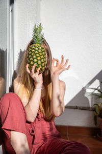 Portrait of woman holding fruit at home