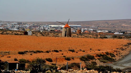 Traditional windmill and buildings in city against sky