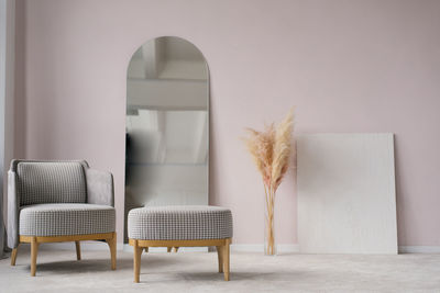 Classic modern grey armchairs, ottoman, mirror, pampas grass dried flowers in a vase