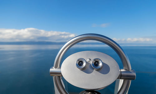 Close-up of binoculars against sky