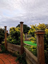 Wooden posts on field against sky