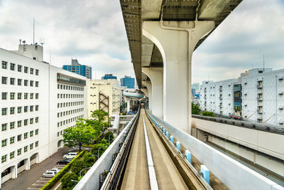 Road amidst buildings in city against sky