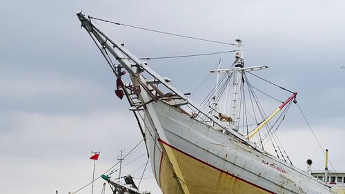 Ship moored on shore against sky