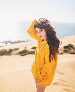 Portrait of young woman standing at beach