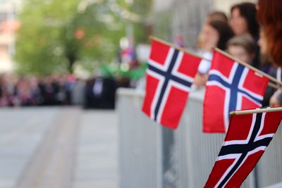 People holding norwegian flags in city
