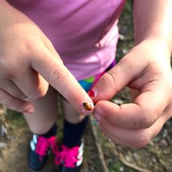 Low section of people holding hands on field