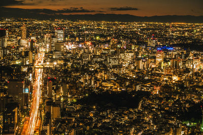 High angle view of illuminated cityscape against sky at night