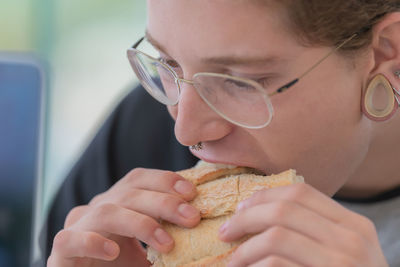 Close-up of man eating sandwich
