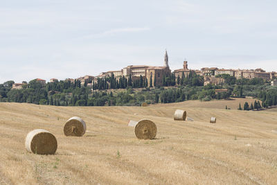 Hay bales on field against sky