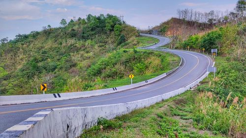 High angle view of road amidst trees against sky