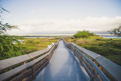 Walkway amidst sea against sky