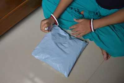 High angle view of woman holding hands on bed at home