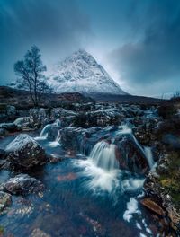 Scenic view of waterfall against sky