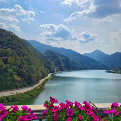 Scenic view of lake by mountains against sky