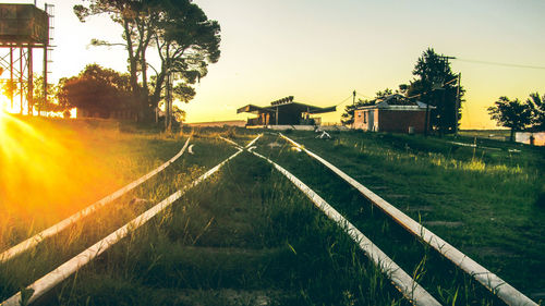 Road amidst buildings against sky during sunset