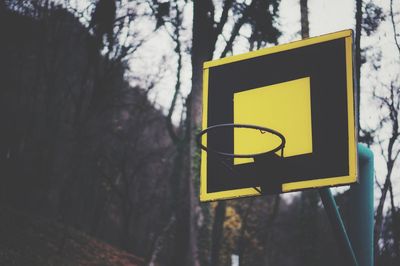 Close-up of road sign against trees