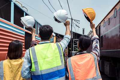 Rear view of people with umbrella standing on street