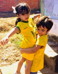 Brother carrying sister in yard