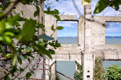 Old building by sea against sky