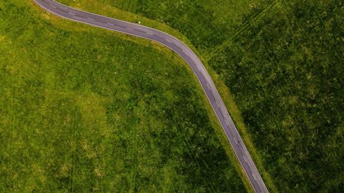 High angle view of road amidst grassy field