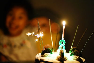 Close-up of birthday cake with candles in darkroom