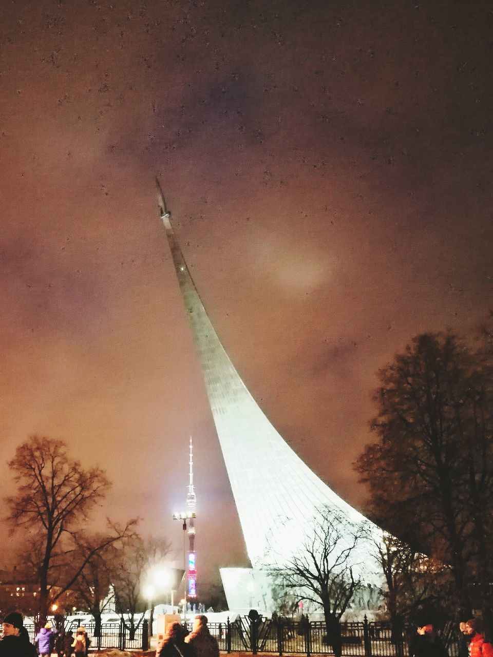 LOW ANGLE VIEW OF ILLUMINATED CITY AT NIGHT