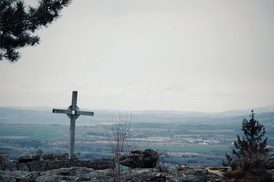 Cross on landscape against sky