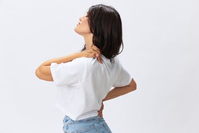 Side view of woman standing against white background