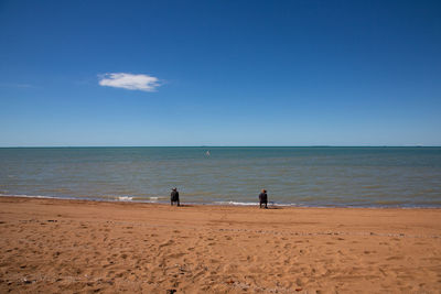 Scenic view of sea against sky of 2 men fishing 