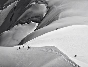 Aerial view of silhouette hikers on snowcapped mountain
