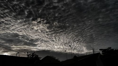 Low angle view of silhouette trees against dramatic sky