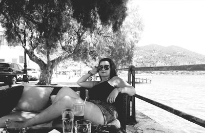 Young woman using phone while sitting on chair