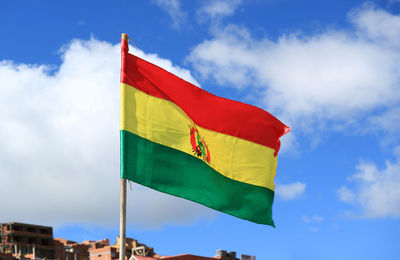 National flag of the plurinational state of bolivia waving on sunny blue sky, bolivia, south america