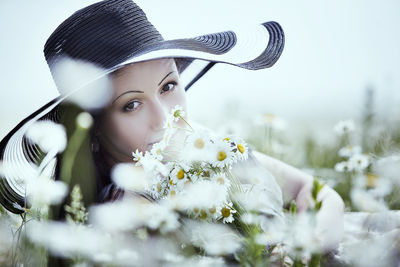 Portrait of woman with flowers on field