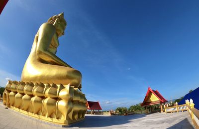 Statue of temple against building against sky