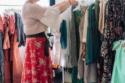 Side view of woman choosing dress at store