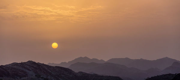 Scenic view of silhouette mountains against sky during sunset