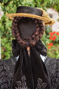 Rear view of mature woman with braided hair wearing hat