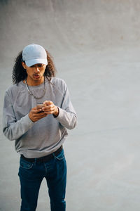 High angle view of young man using mobile phone at skateboard park